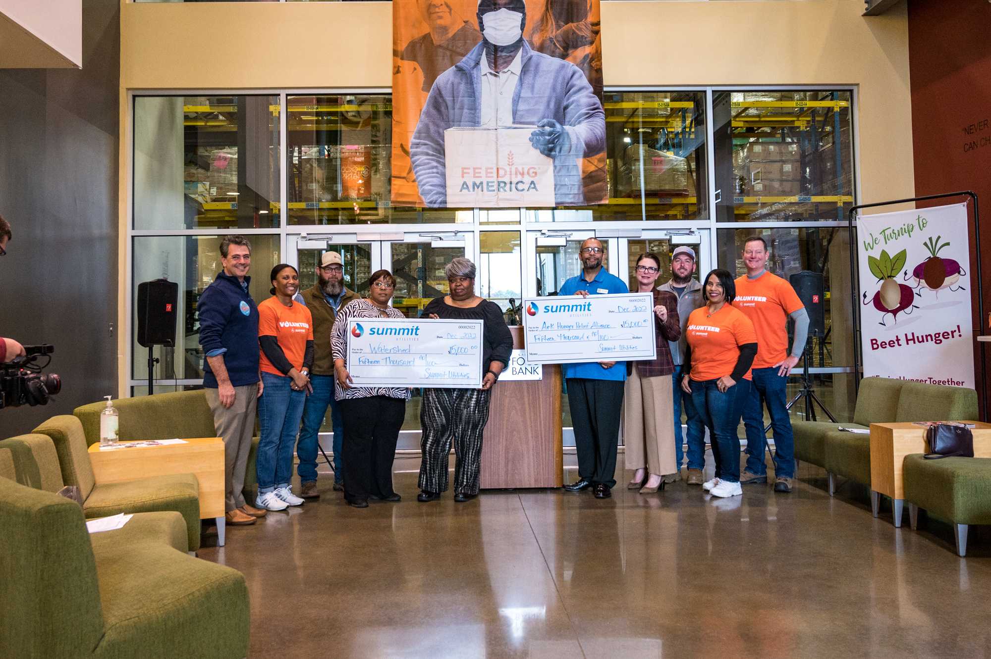 A group of people stand around two large checks
